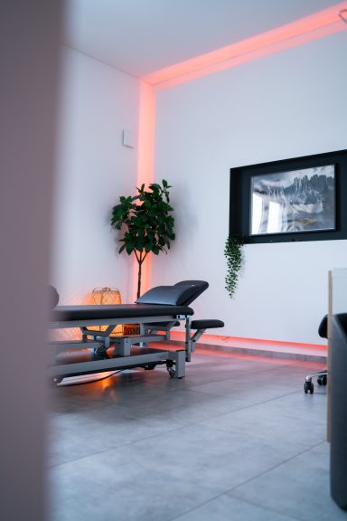Behandlungsraum mit modernem Tisch, Pflanzen und warmem Licht.
