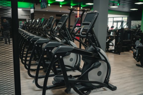Reihe von Crosstrainern in einem modernen Fitnessstudio.