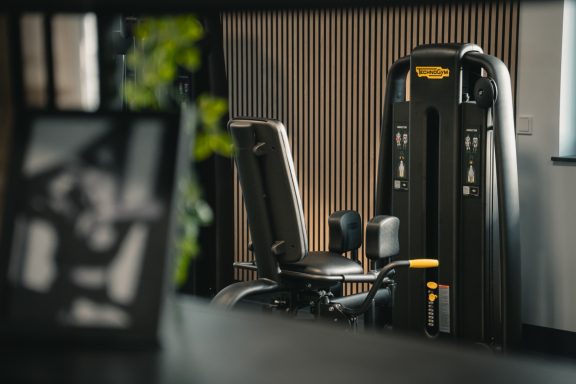 Fitnessgerät in modernem Raum, mit unscharfem Bild eines Rahmens im Vordergrund.